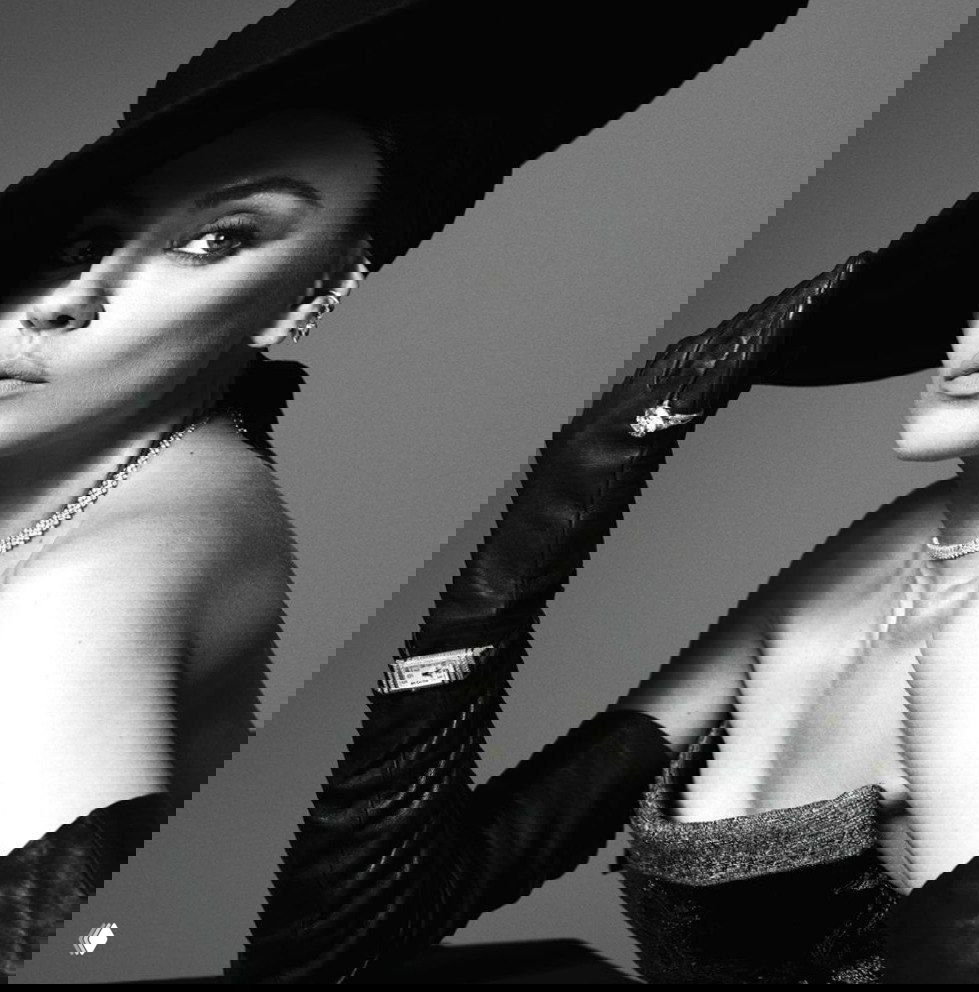 Черно‑белая студийная фотография в профиль: широкополая шляпа, длинные кожаные перчатки и элегантное ожерелье, винтаж.