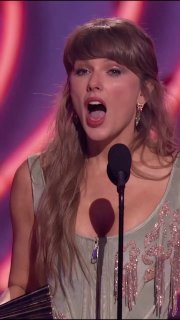 Тейлор Свифт принимает речь на сцене iHeartRadio Music Awards 2026 в фисташковом корсете и мини-платье, микрофон и статуэтка в кадре.