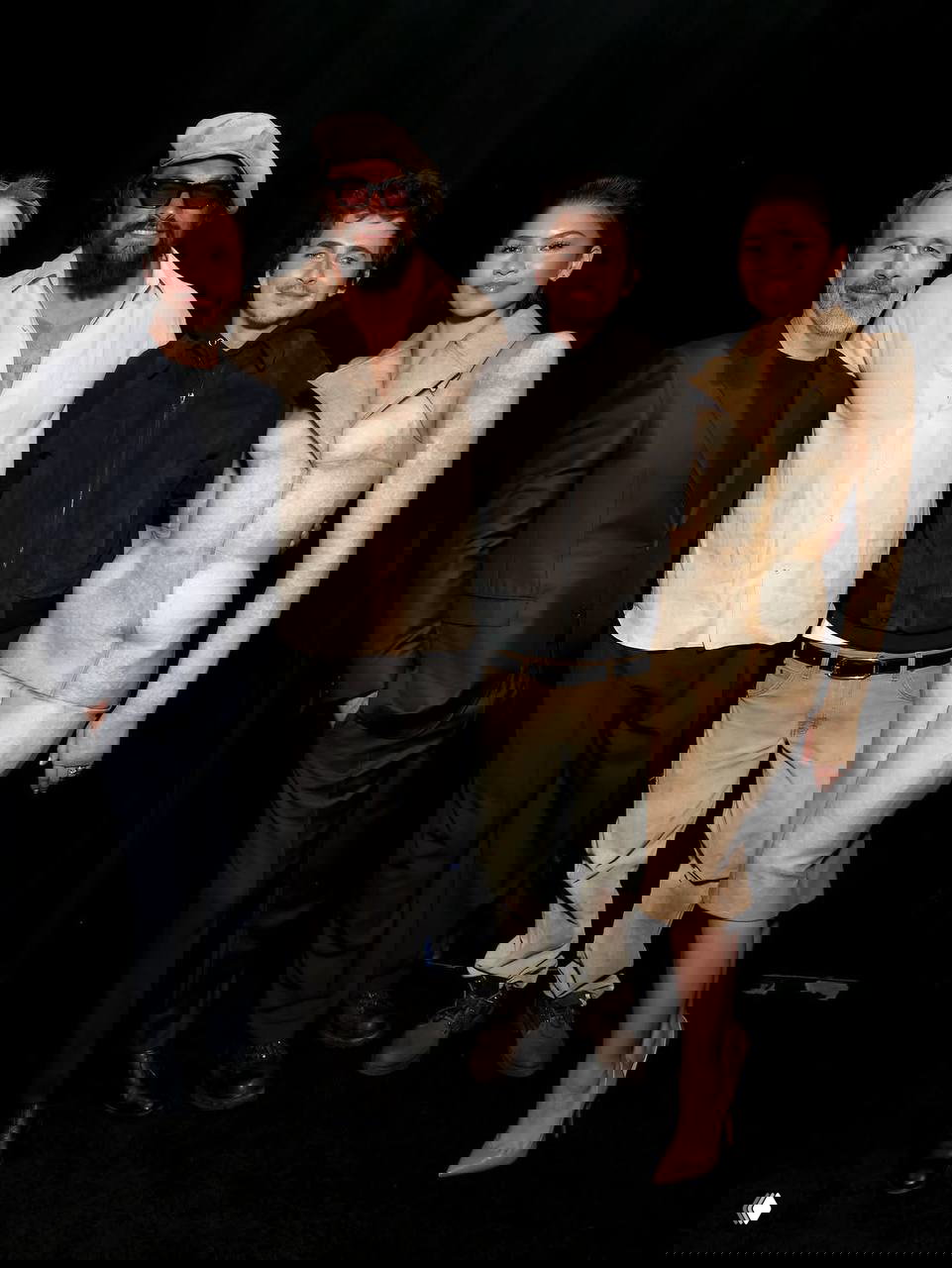 Групповое фото участников презентации на чёрном фоне: несколько человек стоят в ряд, сочетание повседневных и сценических образов, дружеская атмосфера после показа.