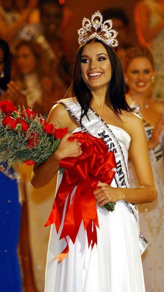 Улыбка победительницы в вечернем платье и короне — современный титульный кадр, демонстрирующий эволюцию макияжа, причёсок и сценического имиджа.