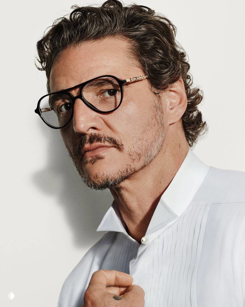 Портрет мужчины в очках Chanel на светлом фоне, строгий элегантный образ — кадр рекламной кампании коллекции летних очков.