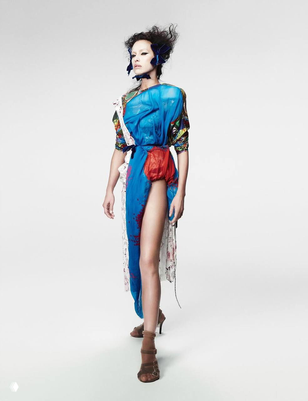 Ирина Шейк в ярком синем платье с акцентной скрытой деталью, художественная постановка и акцент на форме и движении ткани в студийной съёмке.