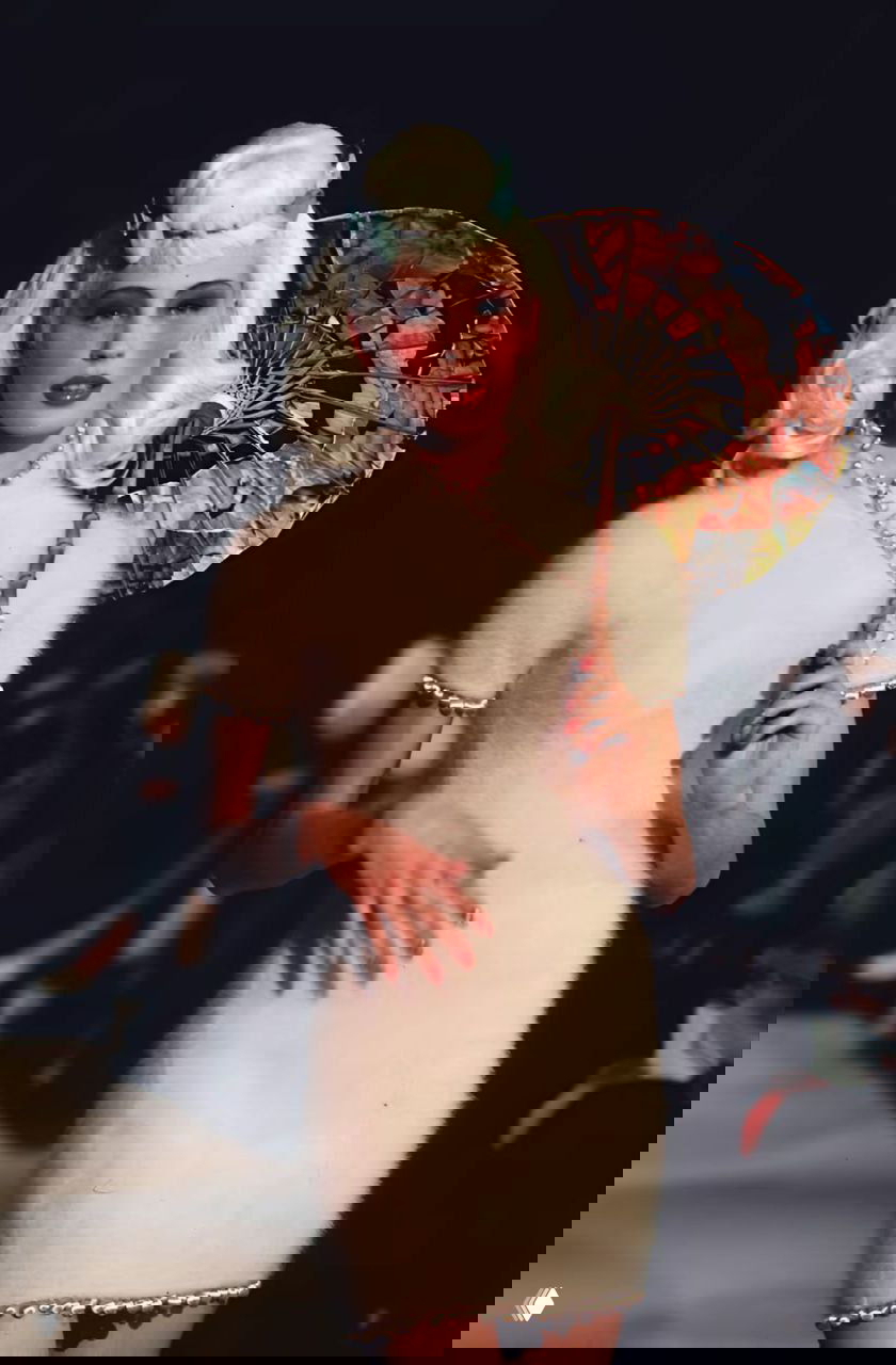 Модель в пушистом белом платье и с расписным японским зонтом на показе Dior осень‑зима 1997, мягкая текстура ткани, ретро‑свет и сцена.