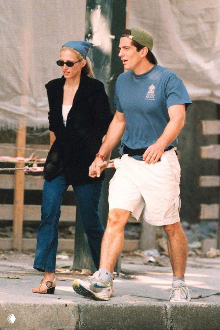 Романтический уличный кадр: мужчина и женщина обнимаются на фоне городской архитектуры в спокойной монохромной гамме, архивный стиль.