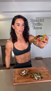 Сенада демонстрирует тако из цуккини (zucchini tortilla tacos) на разделочной доске; кадр подчёркивает здоровую и лёгкую подачу.