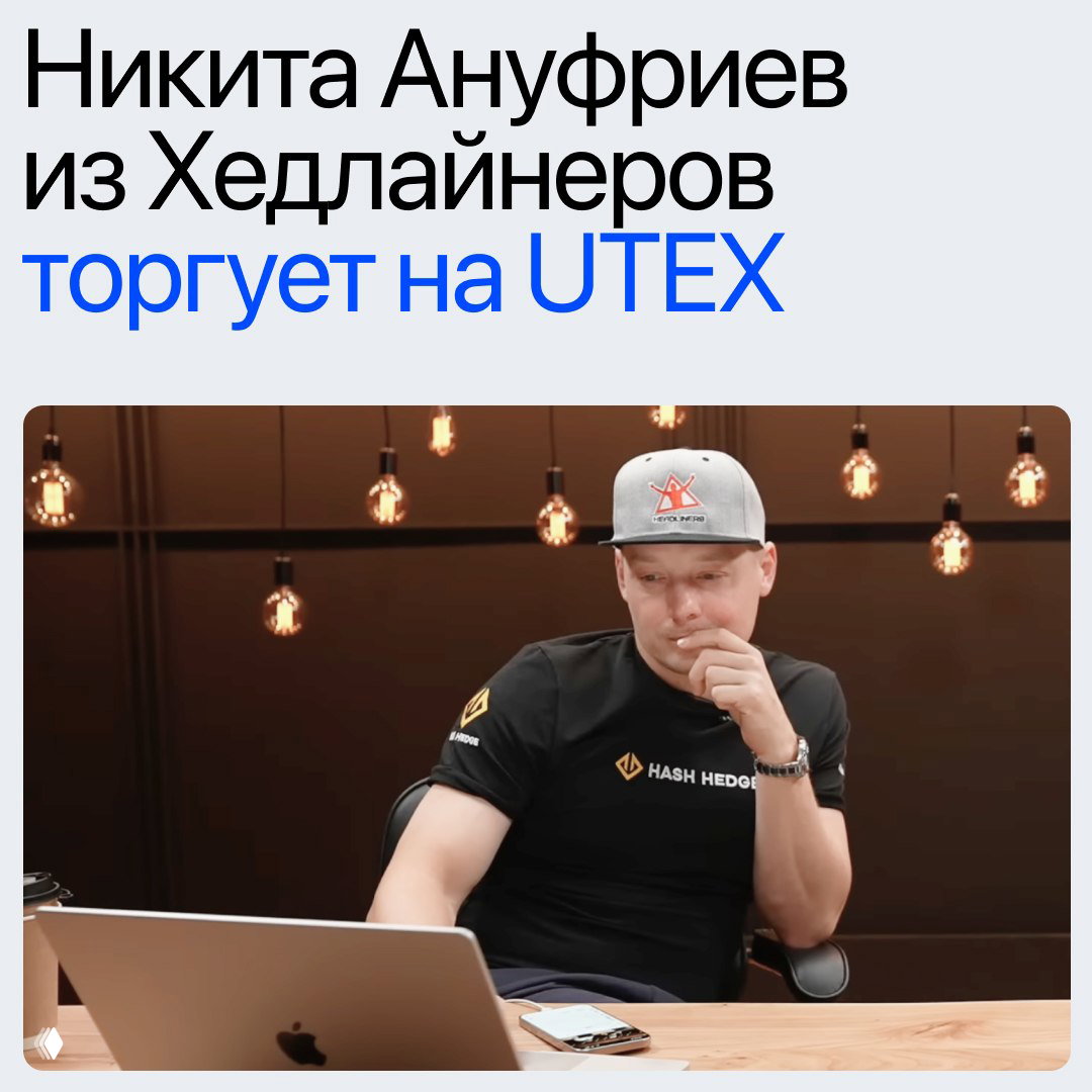 Человек в кепке и футболке за ноутбуком в студии — кадр из YouTube‑материала, рабочая атмосфера и обсуждение торговли.