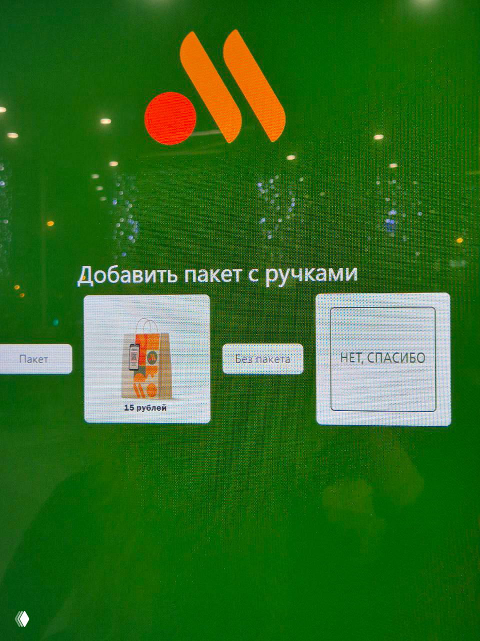Фото экрана киоска самообслуживания в интерфейсе кассы с зелёным фоном: опции «Добавить пакет», «Без пакета» и отдельная кнопка «НЕТ, СПАСИБО», цена 15 руб.