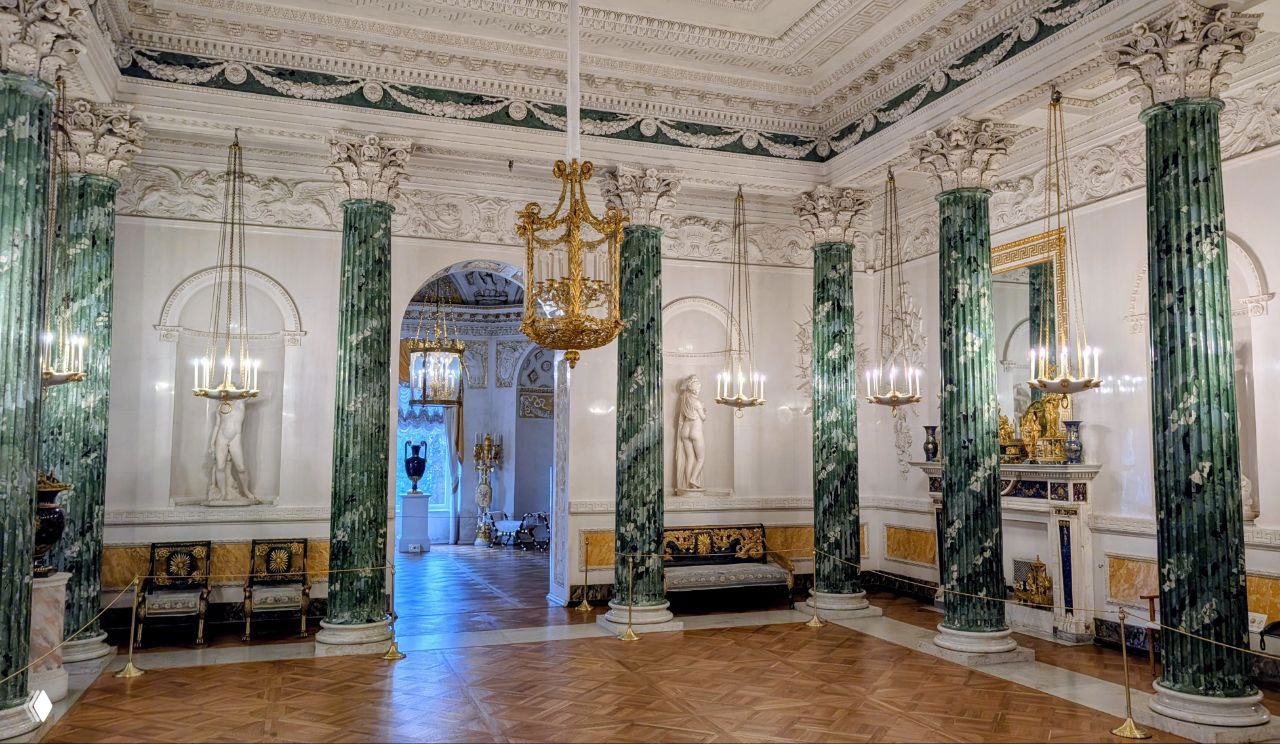 Интерьерный зал с зелёными колоннами и мраморными скульптурами: классические формы и парадное убранство комнат дворца.