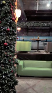 Фрагмент видеоинтерьера: небольшая лаунж-зона с диваном и столиками — современное использование пространства фабрики для мероприятий.