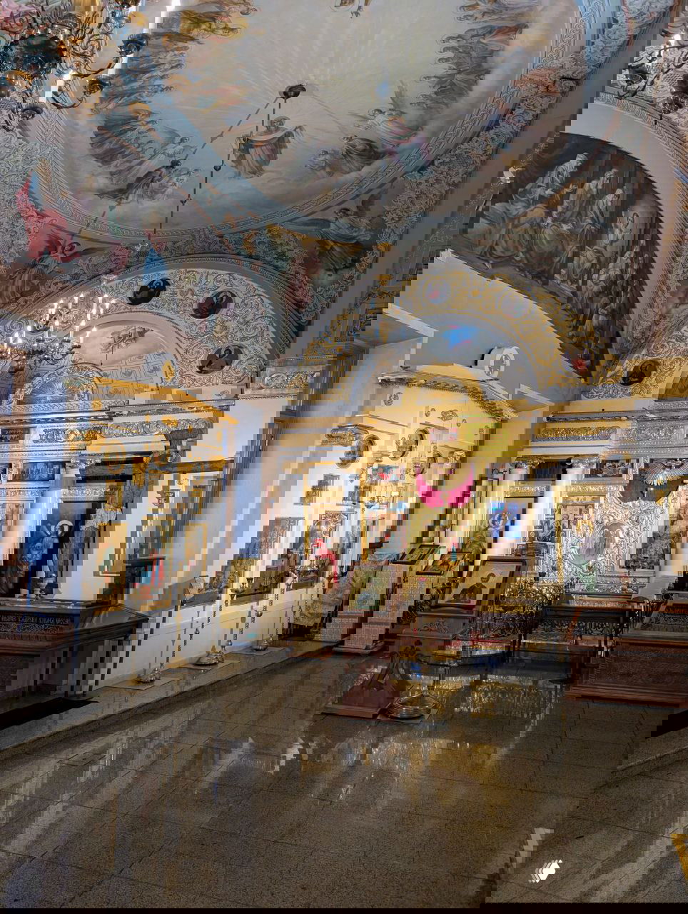 Угол внутреннего пространства: иконы на стенах, позолоченные наличники и роспись на сводах — вид малого зала музей‑храма Святителя Николая.