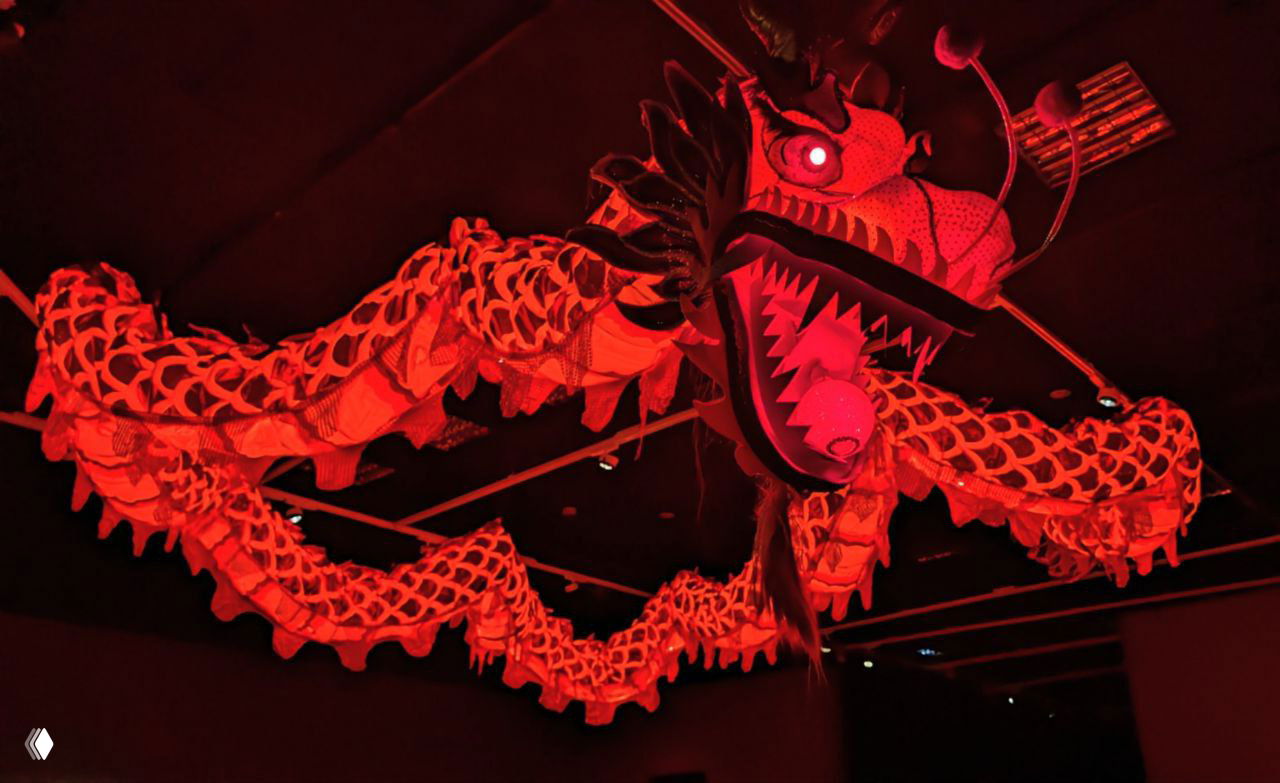 Большой красный дракон, подвешенный к потолку выставочного зала, под яркой подсветкой — традиционный элемент новогоднего парада и инсталляции.
