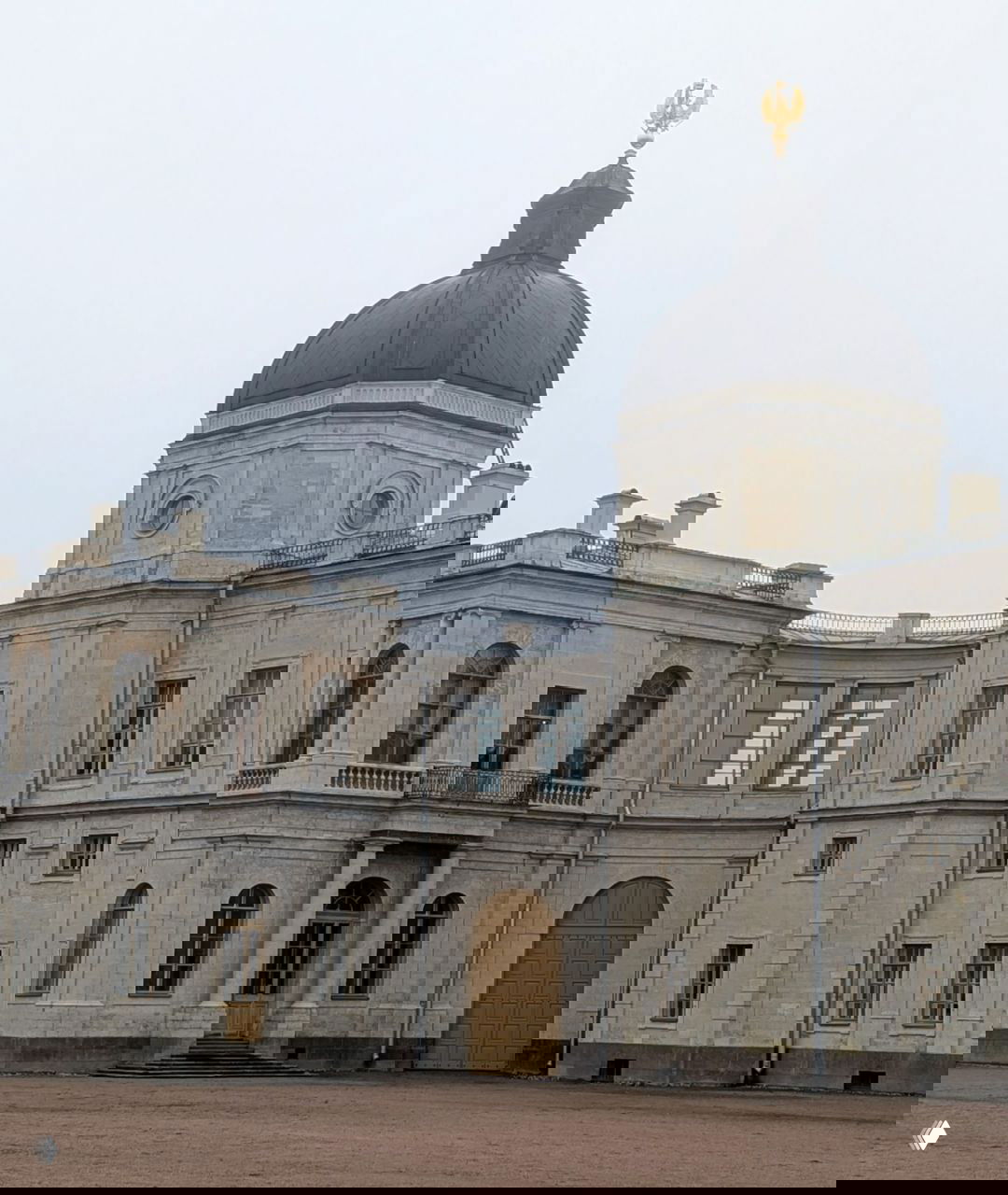 Купол и башня Большого Гатчинского дворца крупным планом: куполообразная кровля, архитектурные детали и декоративный орнамент у основания шпиля.