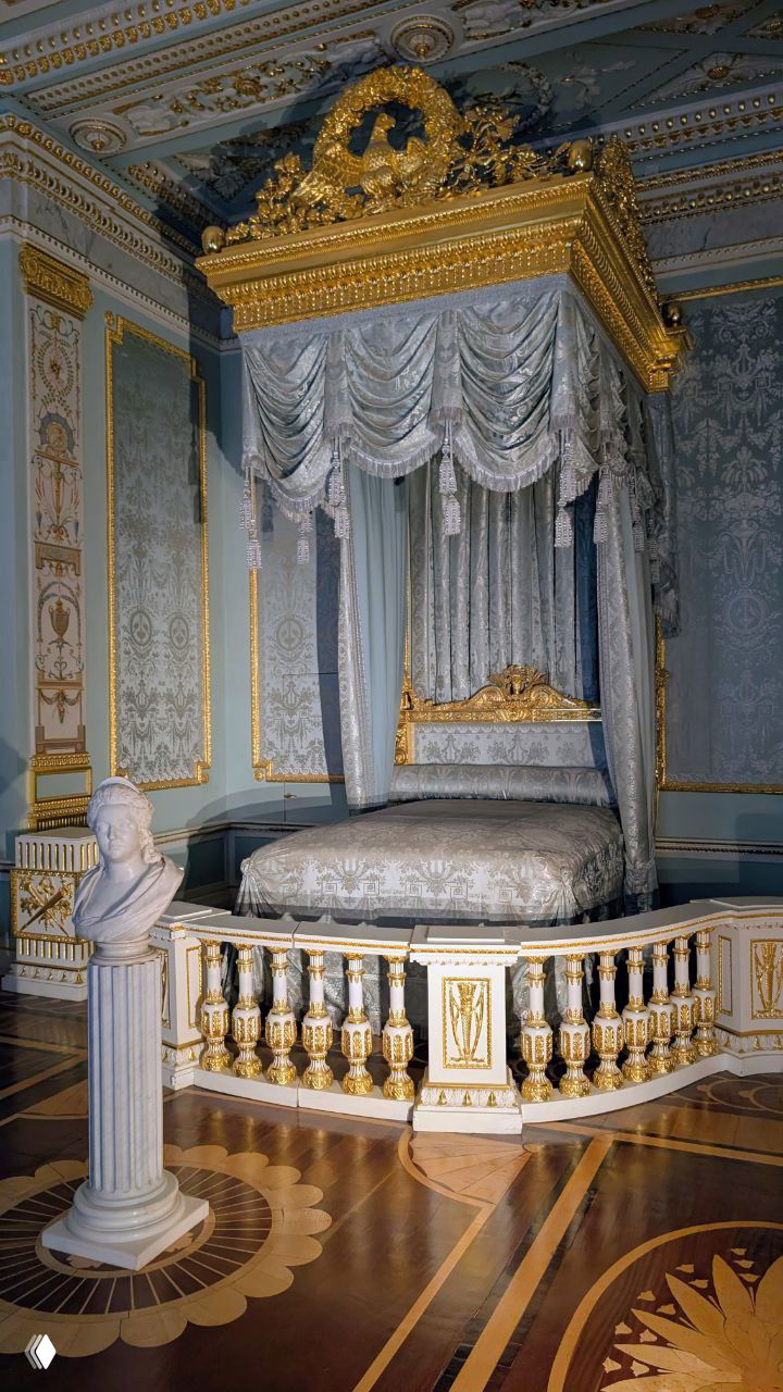 Парадная опочивальня Павла I с балдахином над кроватью, шелковыми стенами и золочёными декоративными элементами интерьера.
