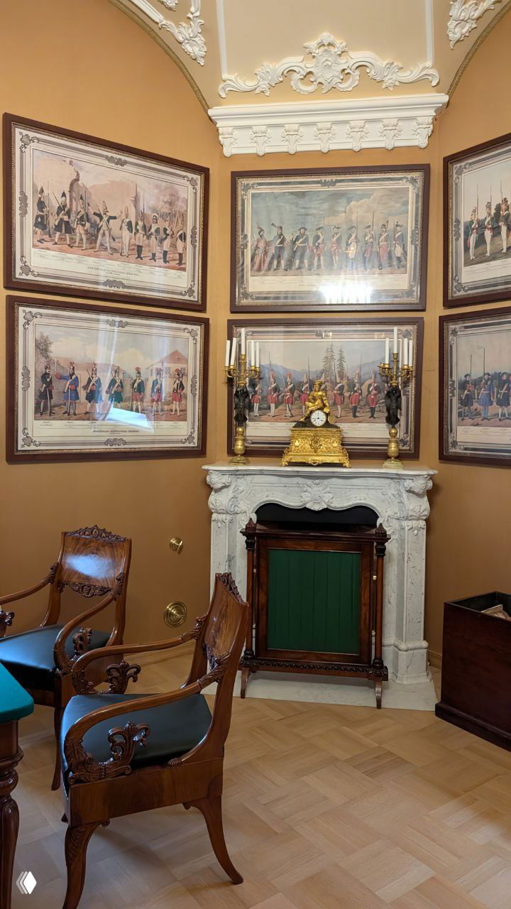 Парадная комната с камином, золотыми канделябрами и серией исторических гравюр на стене — пример скромной аристократической обстановки Николая I.