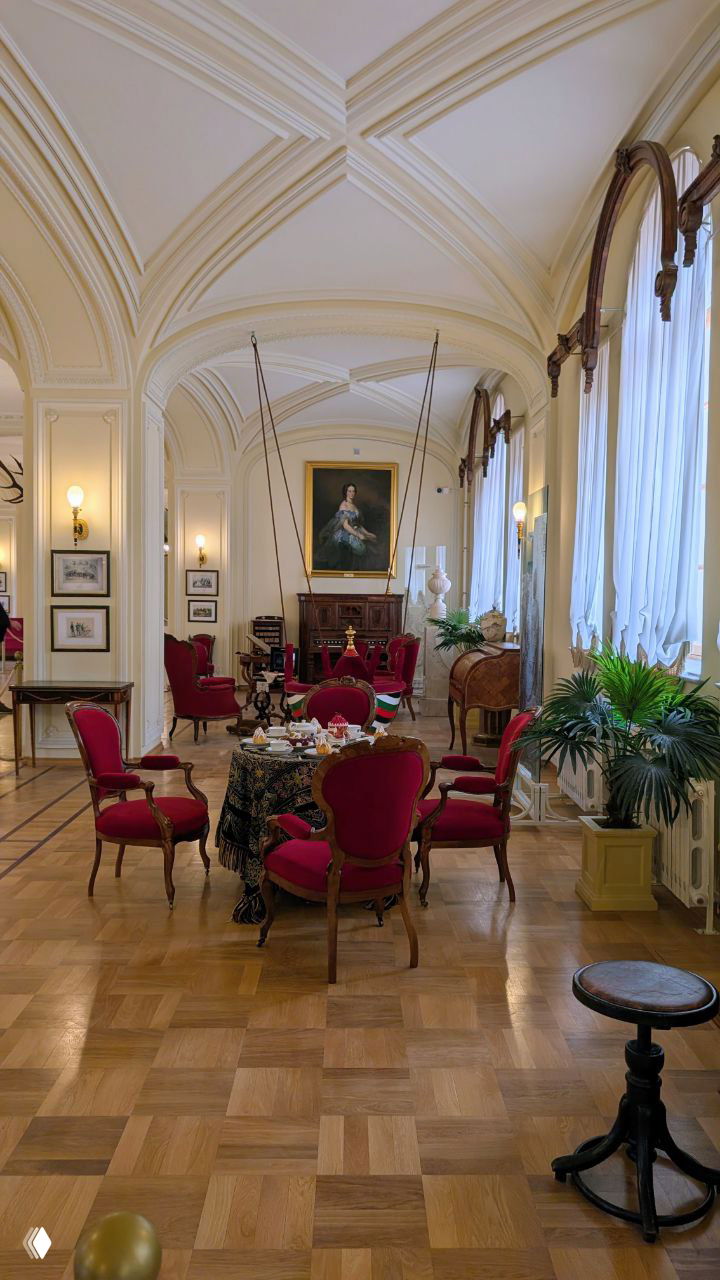 Широкая светлая приёмная с высокими арочными потолками, столом и стульями красной обивки, зал для приёма гостей и чаепития в гатчинских покоях Николая I.