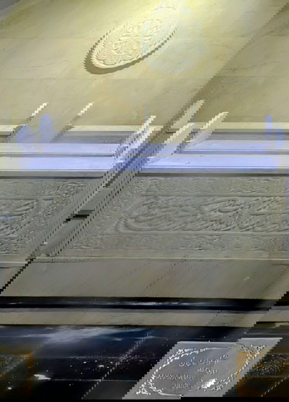 Мраморные надгробные плиты и саркофаги внутри мавзолея рядом с музеем, оформленные арабской вязью и эпиграфикой, вид внутри помещения.