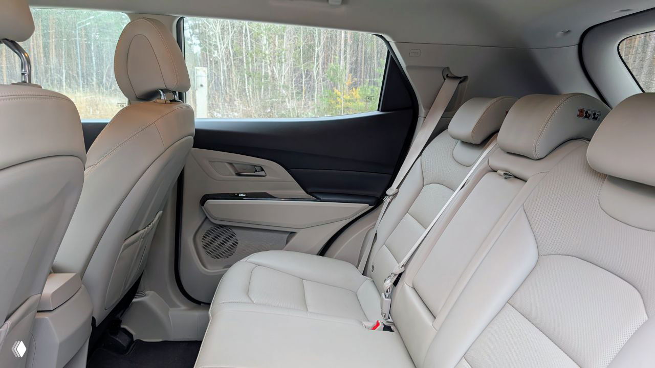 Задний ряд сидений KGM Korando в светлой отделке, три подголовника и свободное место для пассажиров, акцент на комфорте для пары в путешествии.