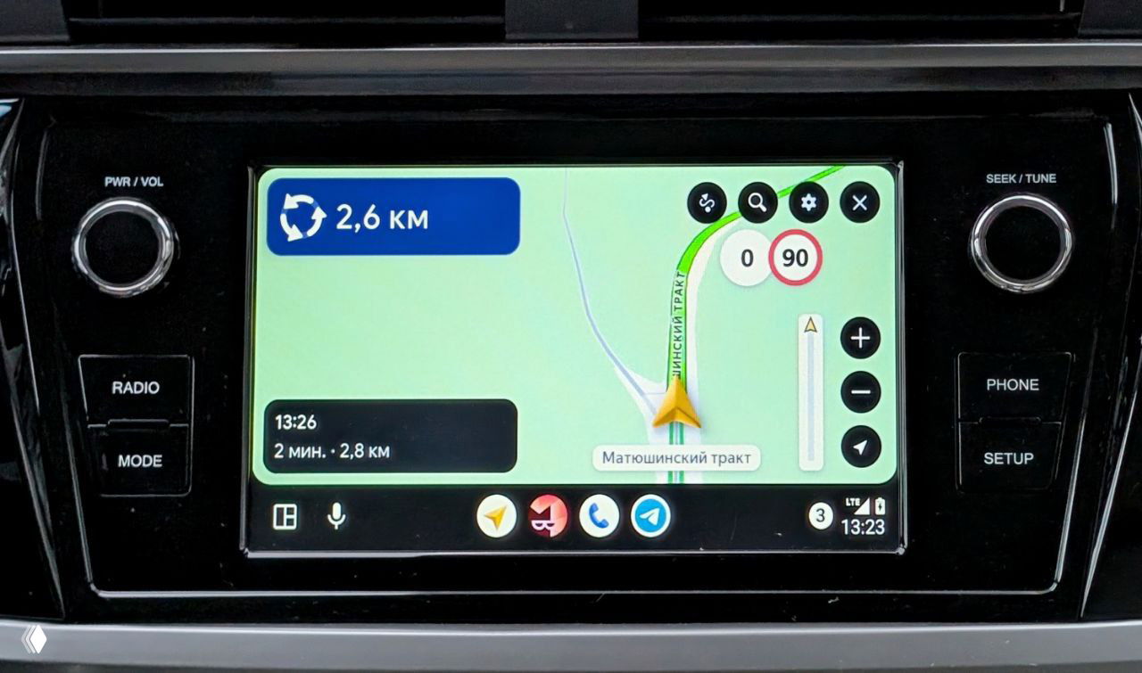 Экран мультимедийной системы KGM Korando с отображением Яндекс.Карт/Android Auto, маршрут и пиктограммы приложений видны на центре управления автомобилем.