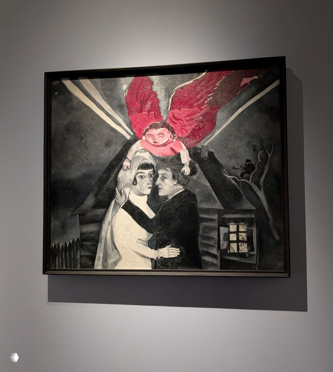 Полотно Шагала: пара под ангелом с ярко-красными крыльями, тёмные тона и акцент на фигурах создают мистическую сцену.