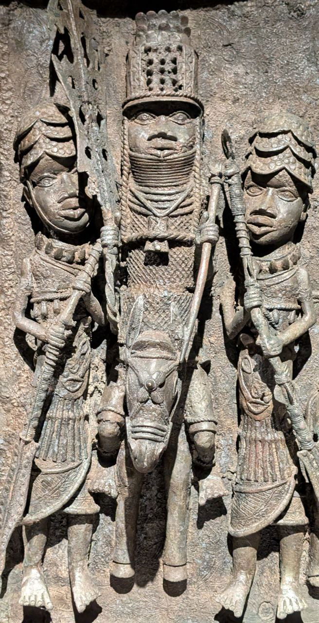 Бронзовый рельеф с центровой фигурой и сопровождающими, детализированная композиция в африканской манере, часть коллекции музея.