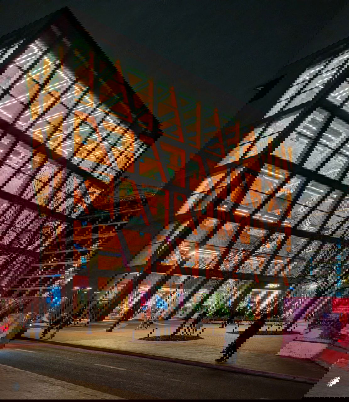 Ночное фото фасада музея Зиларт: медная облицовка, большие стеклянные витрины и освещённый интерьер нового современного здания.