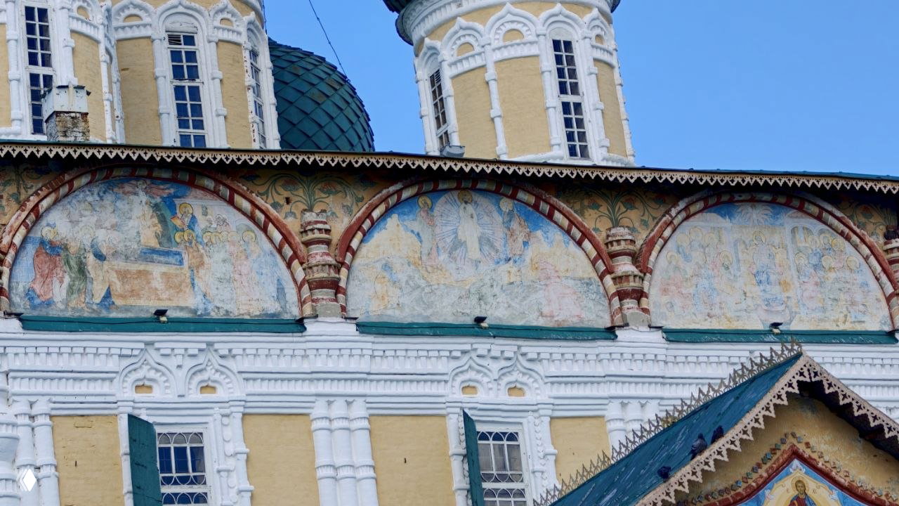 Фрагмент наружных фресок Воскресенского собора: библейские сюжетные сцены в арочных полях, частично выцветшая живопись и орнаментальная декоративная кладка.
