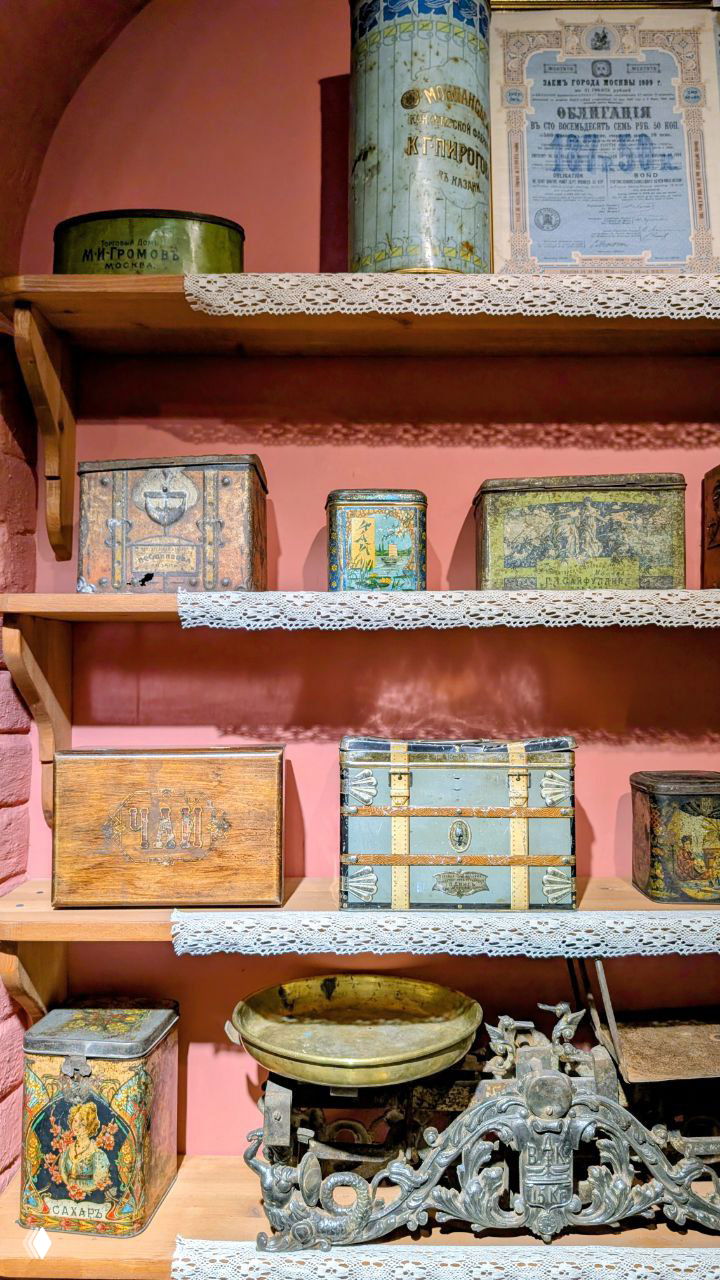 Полки с антикварными коробками и жёсткими чайными чемоданами, металлические весы и банки для чая — коллекционные предметы торговой эпохи