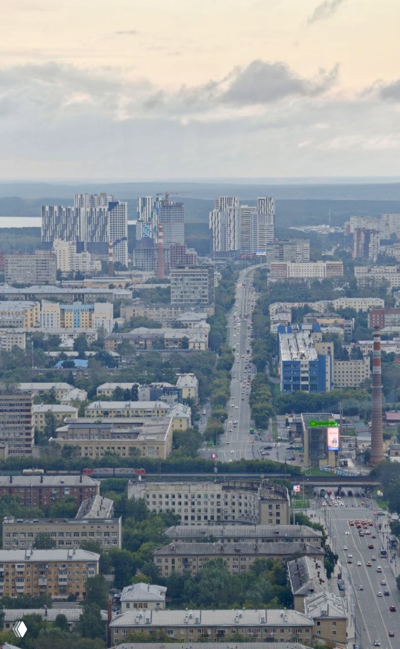 Дальний вид на жилые кварталы и высотные комплексы Екатеринбурга, река и пригородные просторы видны с 52 этажа башни.