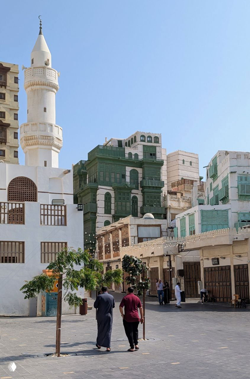 Панорамный вид на квартал Аль-Балад: минарет мечети, разноцветные фасады со множеством равашин и спокойная городская сцена.