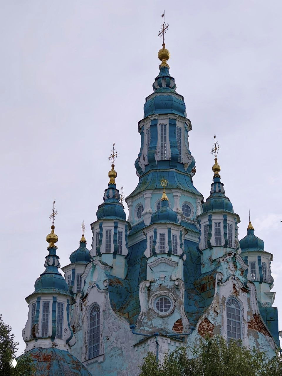 Купола и башни Спасо‑Преображенского храма крупным планом: элементы сибирского барокко, золочёные кресты и следы времени на фасаде.