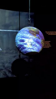 Подвешенный светящийся глобус в затемнённой части экспозиции — инсталляция, демонстрирующая географические представления и диорамы.