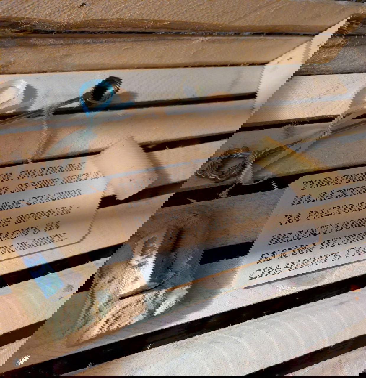 Близкий план печатных приспособлений, металлическая ложка и бумажная этикетка с текстом о недостающих шрифтах — музейные предметы типографии.