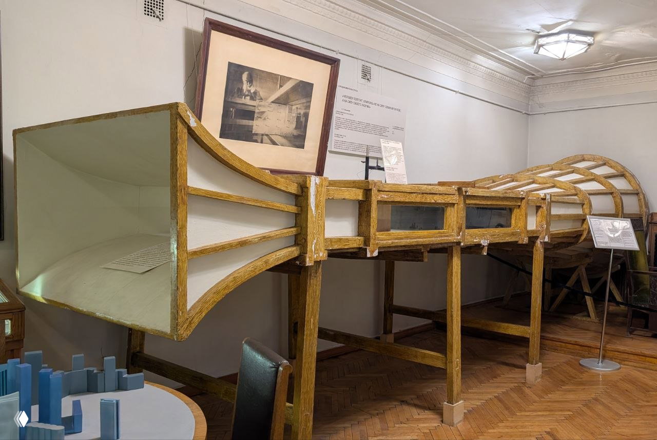 Большая деревянная конструкция аэротрубы или каркас старой аэрофизической установки в экспозиции музея, вид сбоку на деревянный каркас и обшивку.