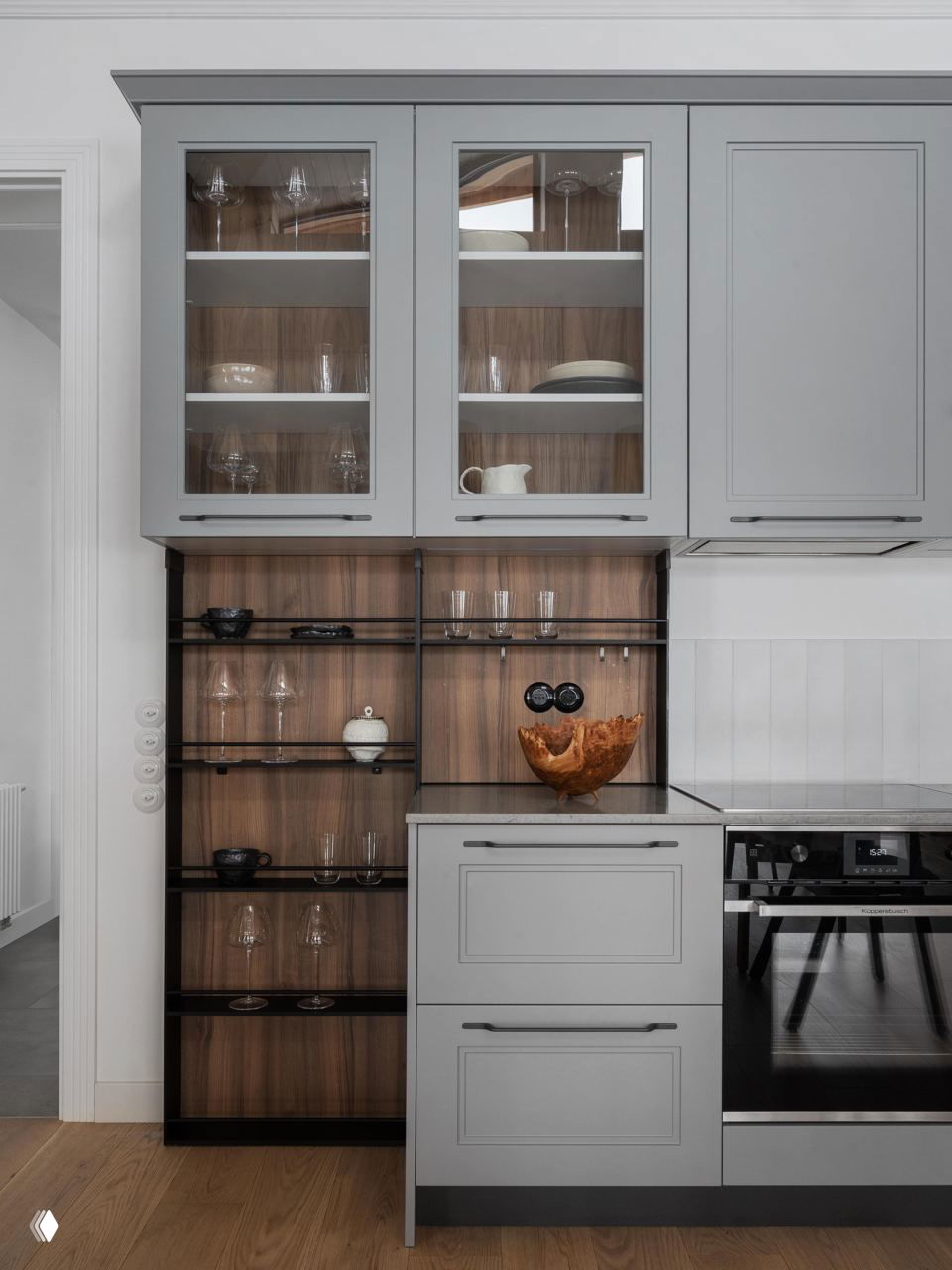 Кухонная секция с серыми фасадами, открытыми деревянными полками и минималистичной организацией пространства в скандинавском духе.