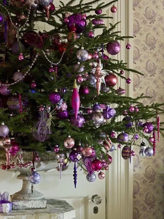 Тёмная ёлка в светлом помещении: проволочная корзина с тканевой подкладкой как основа, подарки и декоративная гирлянда на полу.