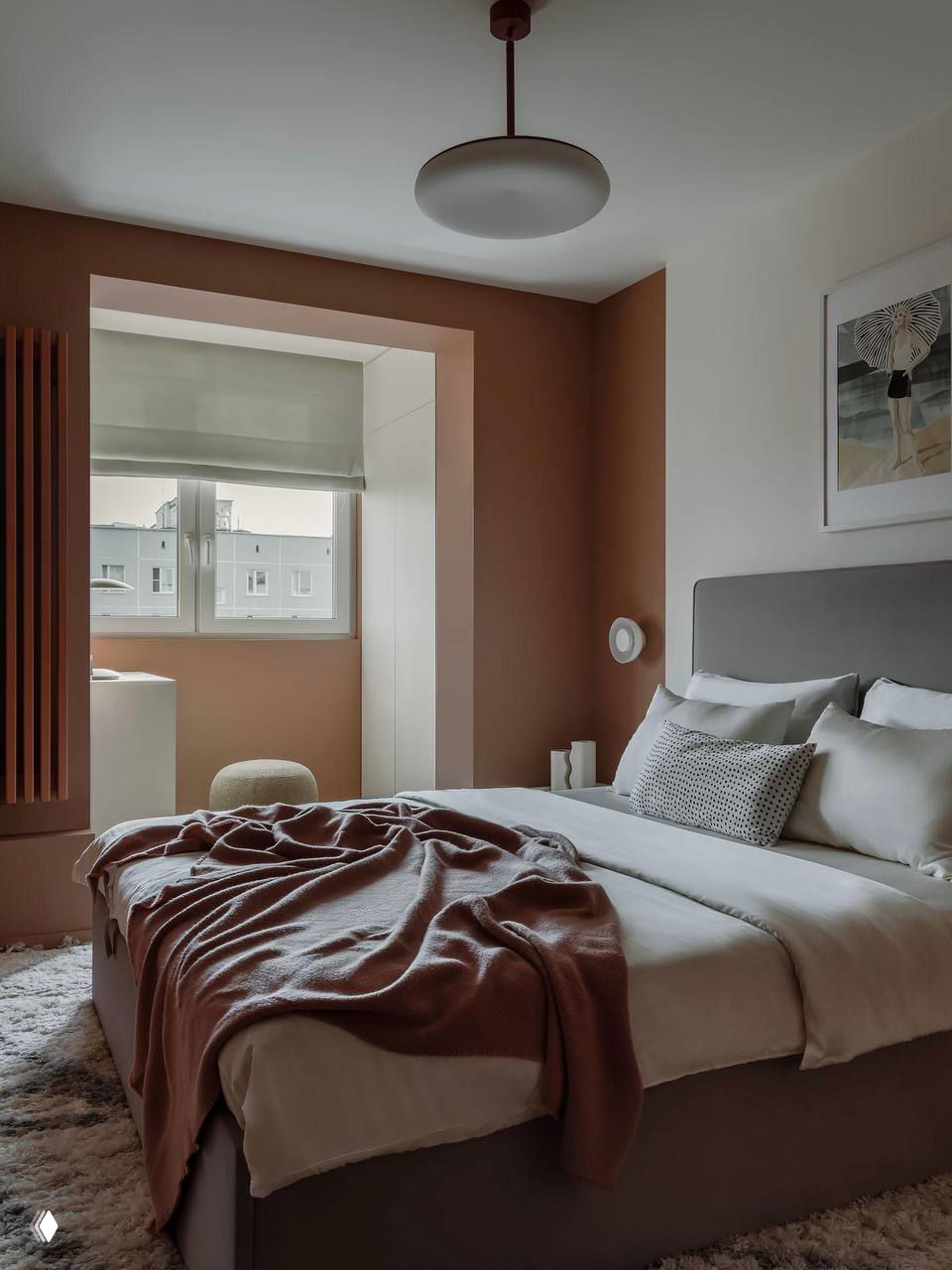 Минималистичная спальня с коричневыми тонами стен и простыми декоративными элементами, легкий дневной свет через окно делает палитру мягкой и комфортной.