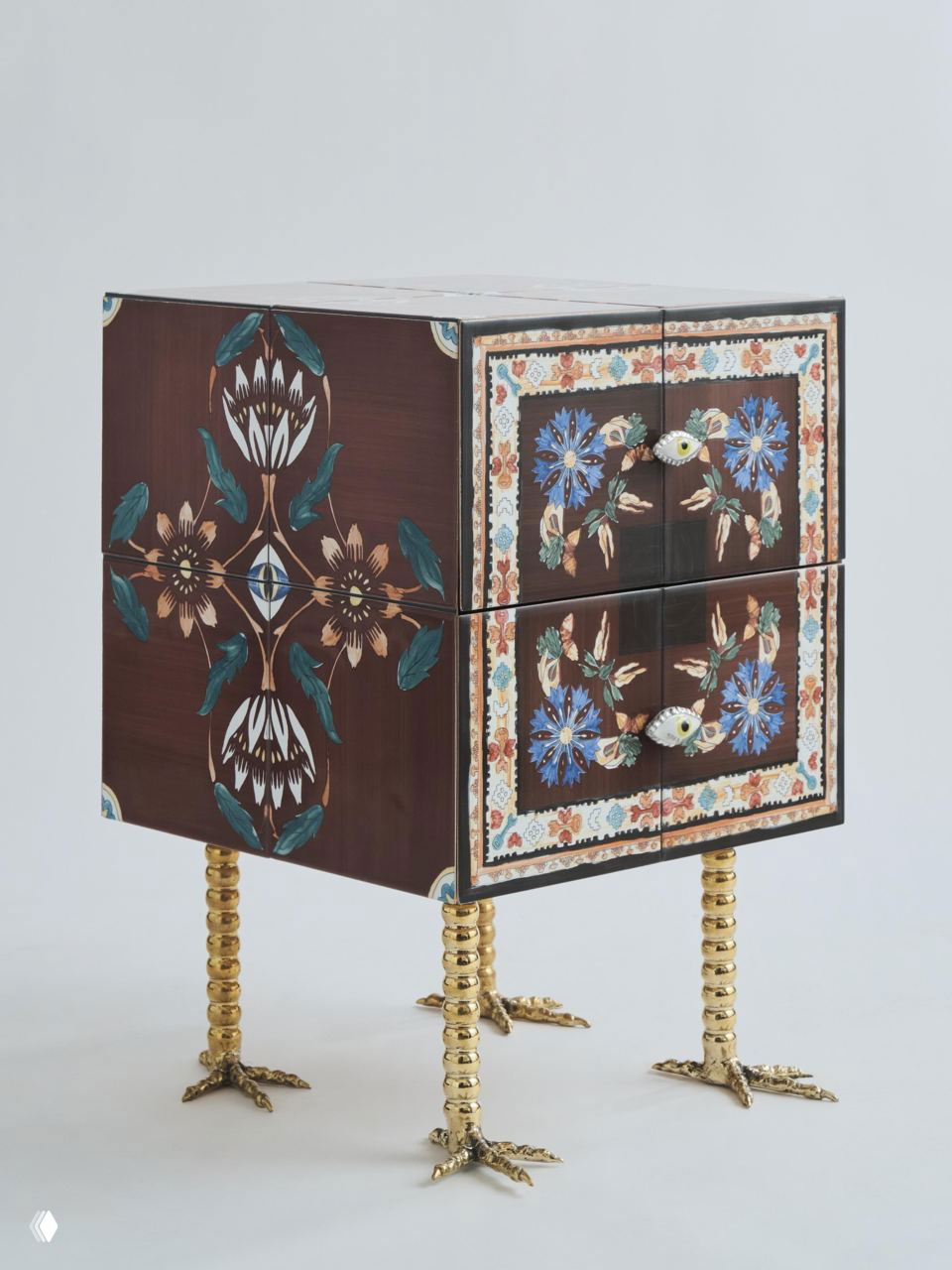 Декоративный ящик с расписным цветочным орнаментом и необычными ручками в виде глаз, стоящий на высоких позолоченных ножках-спиралях в стиле авторской мебели.