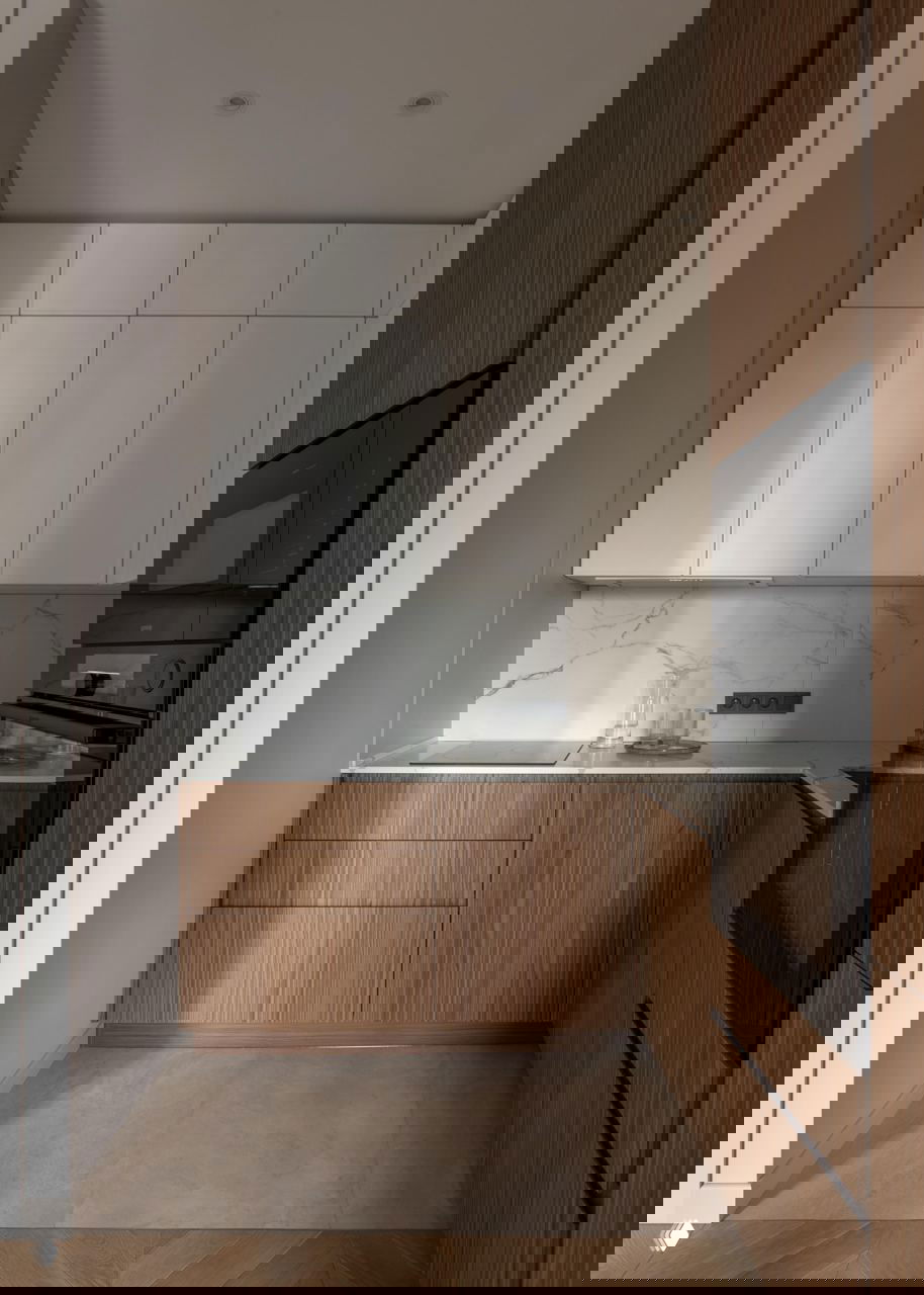 Компактная кухня в джапанди: тёплые деревянные фасады, белые верхние шкафы и мраморный фартук над рабочей поверхностью для лаконичной эстетики.