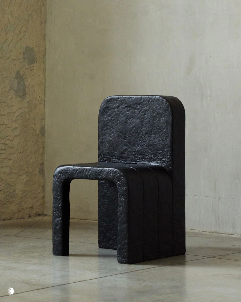 Крупный план одного чёрного стула Echo: округлённая спинка и U‑образное сиденье, выраженная ремесленная фактура покрытия.