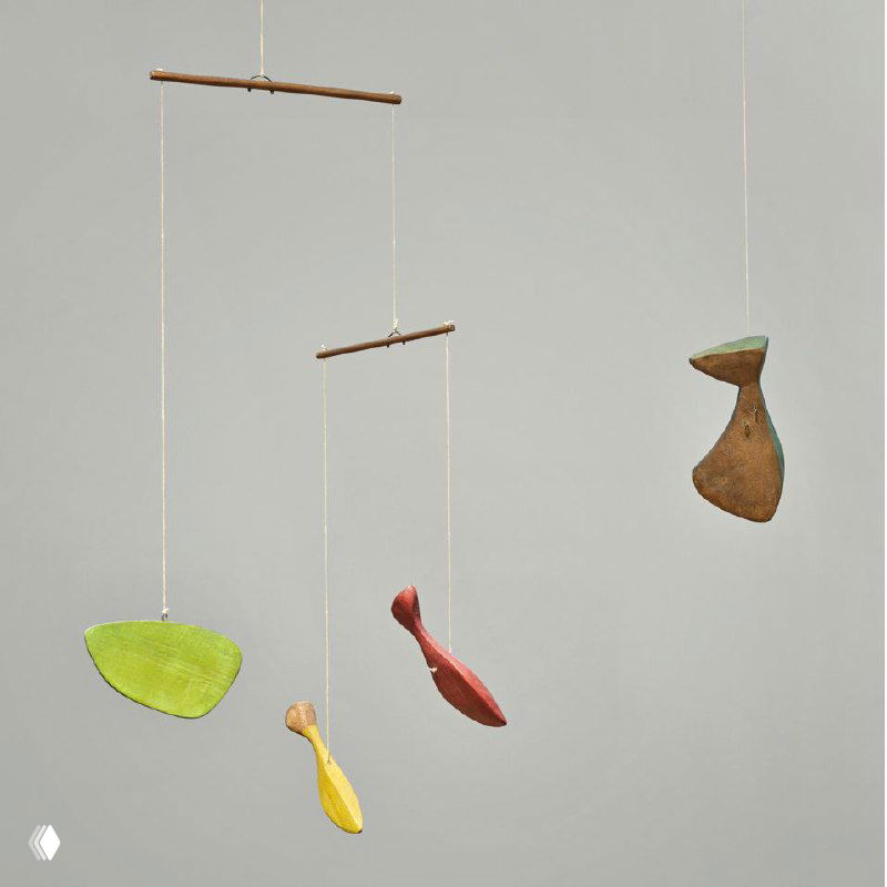 Фрагмент: яркие деревянные подвески жёлтого, красного и зелёного цветов, висящие на тонких нитях; видны следы краски и фактура дерева.