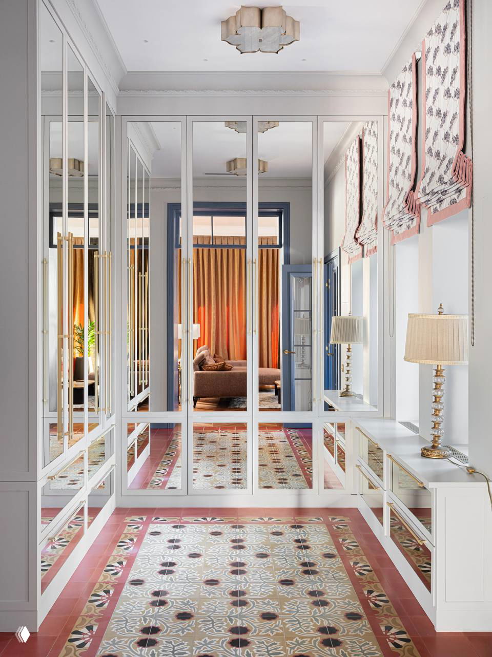 Прихожая с зеркальными дверцами и декоративной плиткой на полу: светлые панели шкафов отражают интерьер и создают ощущение простора и симметрии.