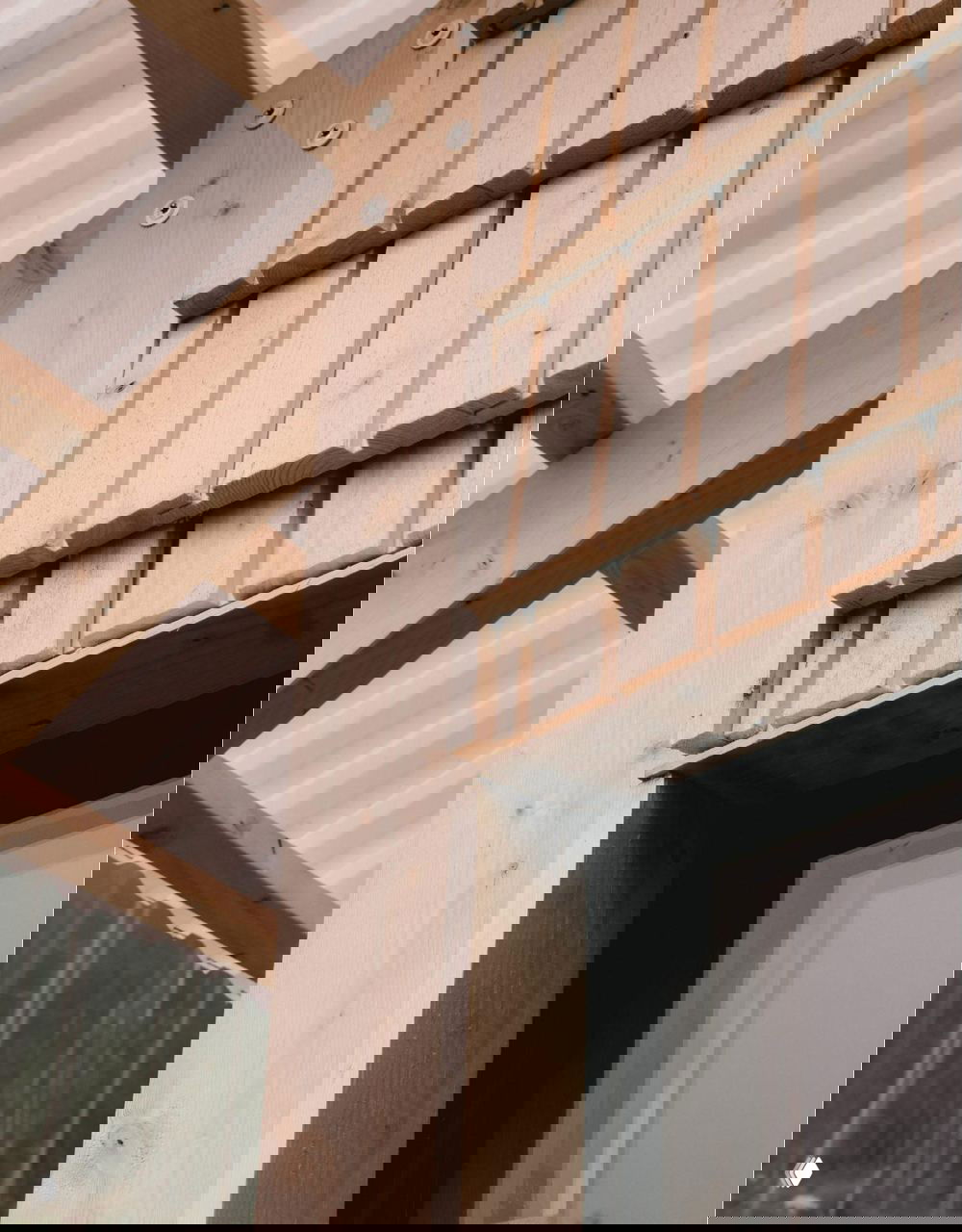 Деталь внешней обшивки: небольшие деревянные пластины и горизонтальные элементы, закреплённые на каркасе, текстура и стыки хорошо различимы.