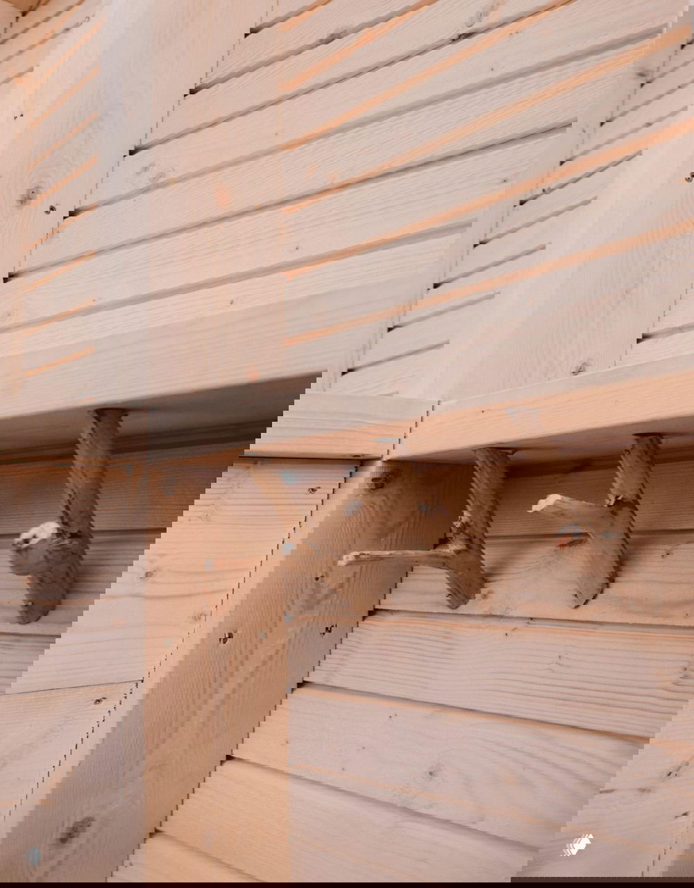 Деревянные мелкие кронштейны и детали отделки внутри сауны; заметны текстура светлого дерева и аккуратные соединения элементов.