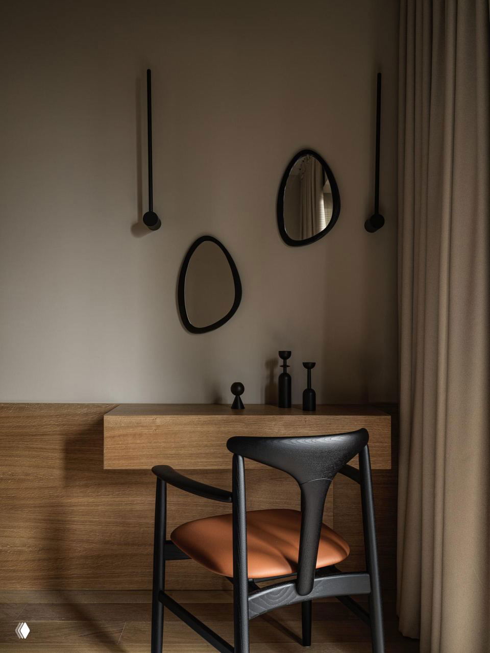 Рабочий уголок с деревянной полкой и черным стулом, приглушенное освещение и монохромные декоративные предметы на фоне нейтральной стены.