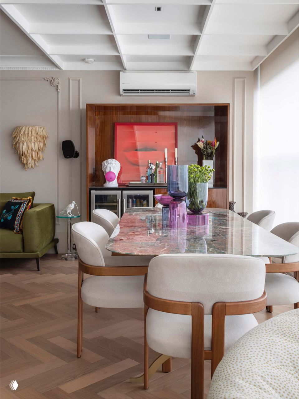 Обеденная зона с мраморным столом, мягкими стульями и декоративными элементами — сочетание современных форм и винтажных деталей в пространстве.