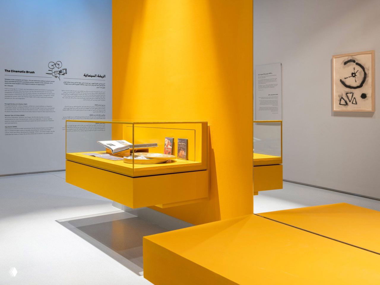 Современная музейная экспозиция: жёлтые выставочные витрины, настенные таблички и минималистичный дизайн зала для презентации архивных материалов.