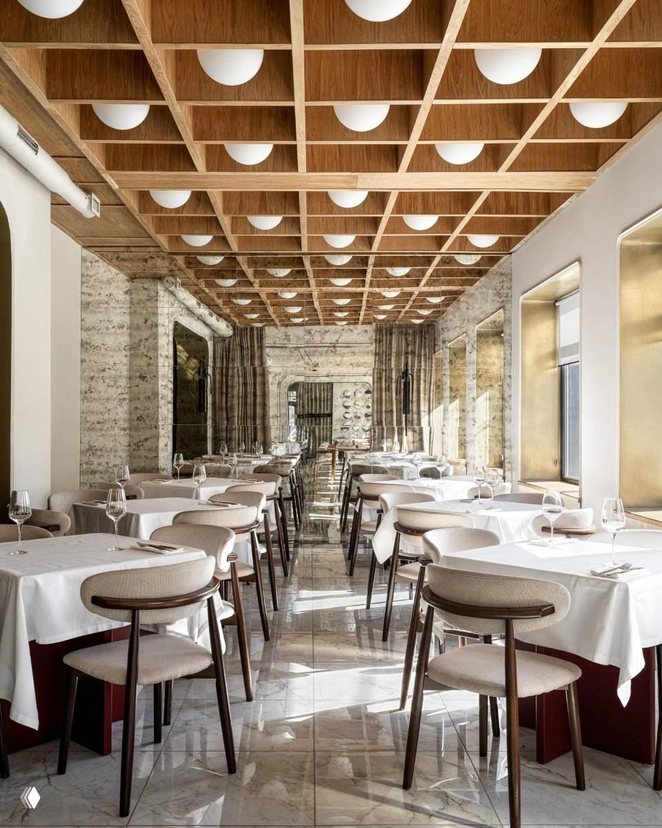 Ресторанный зал с деревянной решетчатой потолочной конструкцией, белыми скатертями и мраморным полом, общественный интерьер премиум‑класса. Представлен в подборке ADDAWARDS 2025.