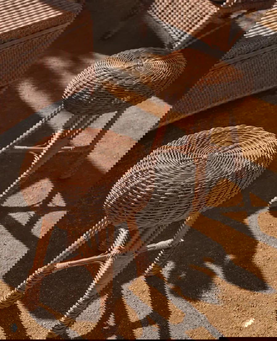 Деталь ротанговых табуретов с круглыми сиденьями: плотное плетение и тональная игра теней подчёркивают фактуру натурального материала.