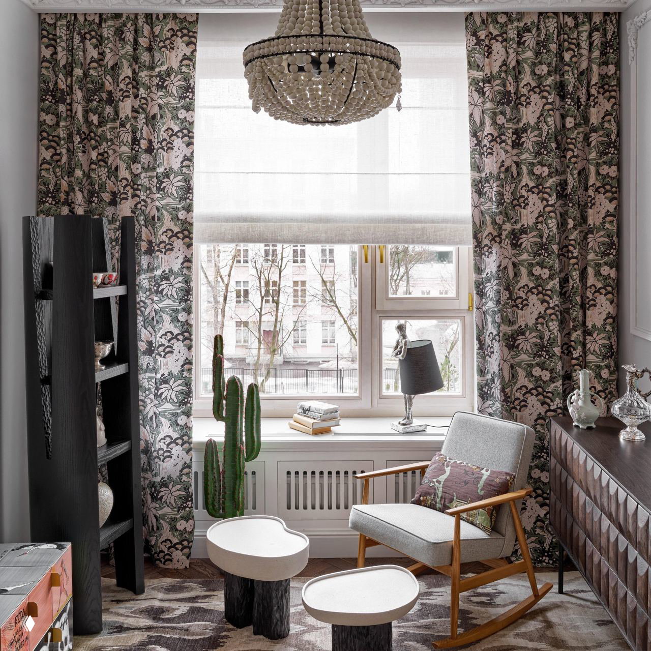 Уютный уголок у окна с креслом-качалкой, римской шторой и круглой люстрой из дерева или бусин — сочетание текстиля и натуральных материалов.