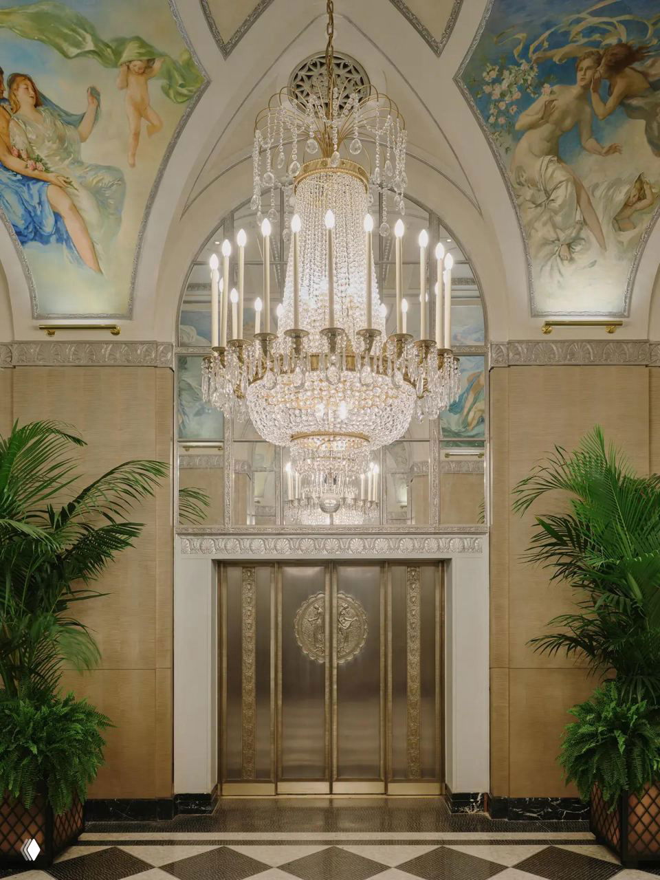 Входная зона с большой хрустальной люстрой, арочными зеркалами и фресками на сводах — украшение обновленного вестибюля отеля.